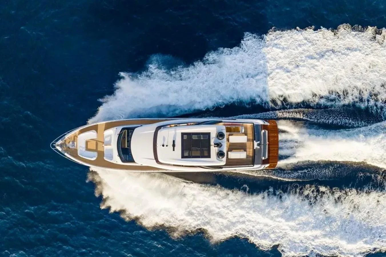 An elegant yacht cruises swiftly through the open sea, leaving a trail of white foam in its wake. aboard SAVIENNE Yacht for Sale