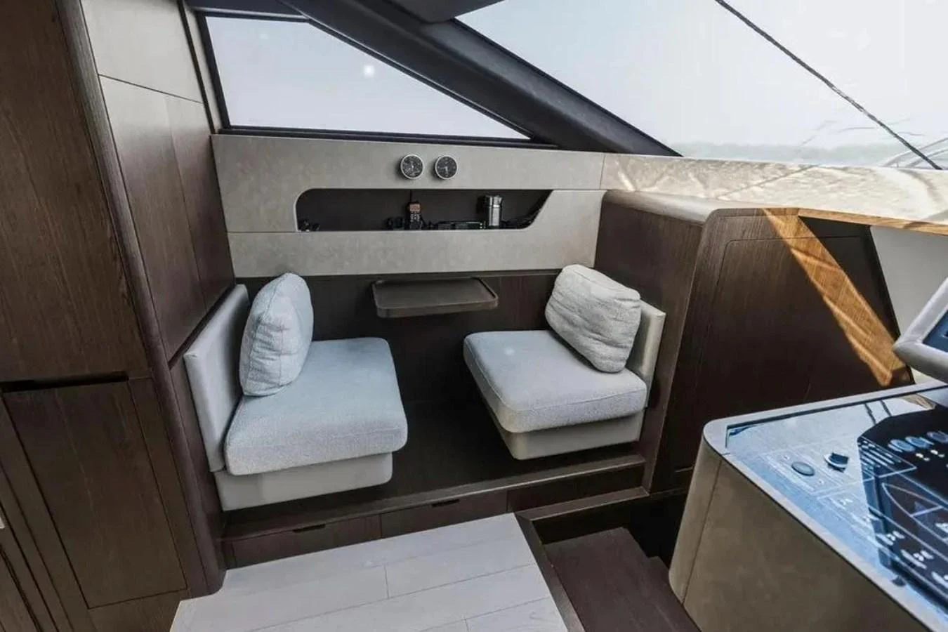 A cozy seating area with plush cushions and a modern helm station nearby. aboard SAVIENNE Yacht for Sale