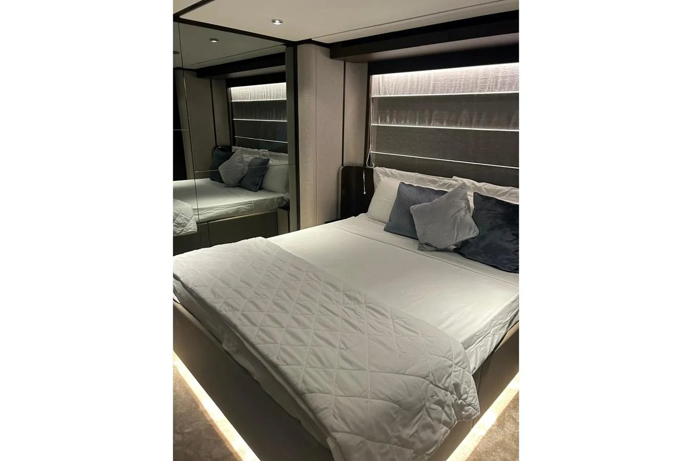 The stateroom features a luxurious bed with plush pillows and modern lighting. aboard SAVIENNE Yacht for Sale