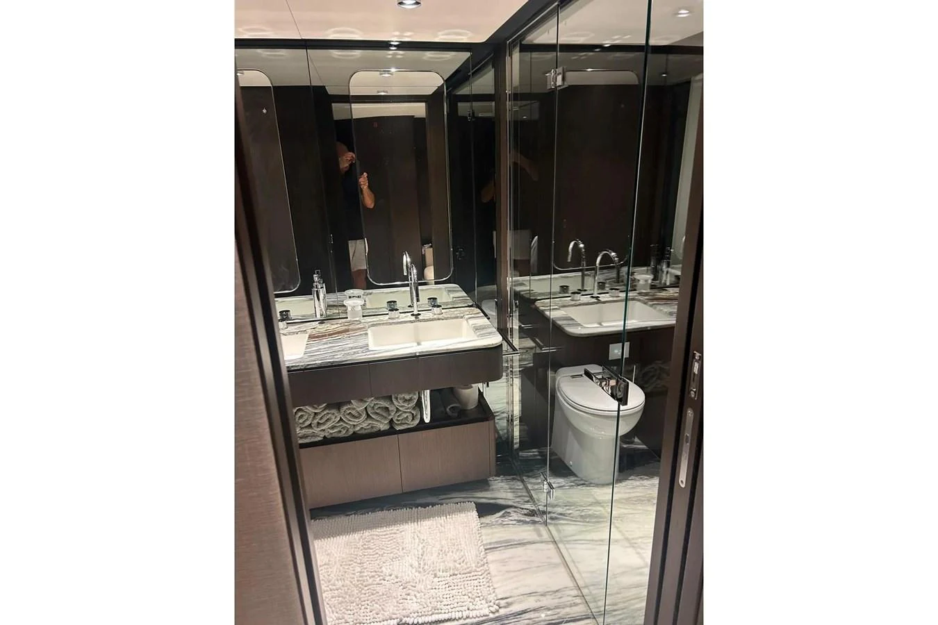 The yacht's bathroom features a modern design with a double sink vanity and a glass-enclosed shower. aboard SAVIENNE Yacht for Sale