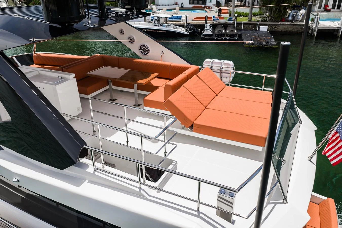 The flybridge features a spacious seating area with vibrant orange cushions and a dining table, perfect for outdoor relaxation. aboard ELENA Yacht for Sale