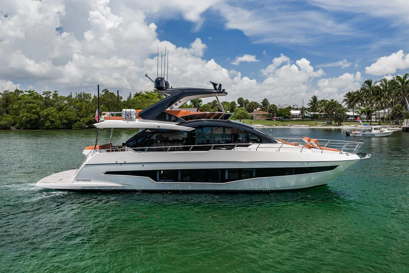 A sleek and modern yacht glides gracefully on calm waters under a bright blue sky. aboard ELENA Yacht for Sale
