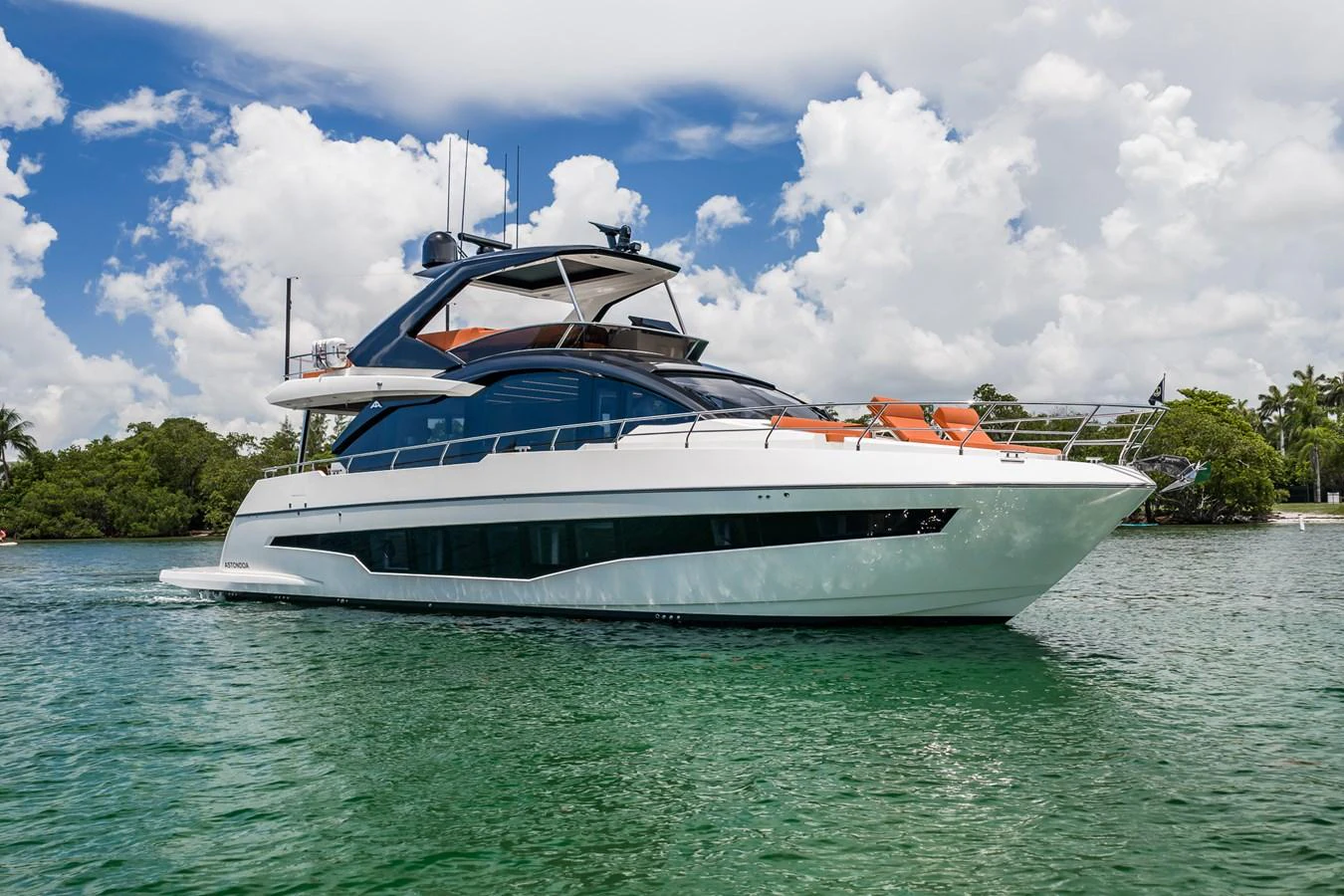 A sleek and modern yacht glides gracefully on calm waters under a bright, sunny sky. aboard ELENA Yacht for Sale