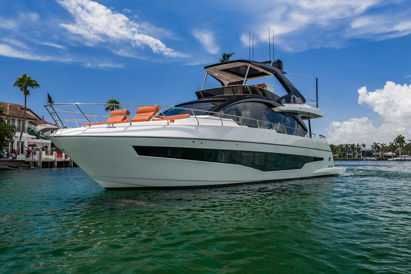 A sleek and modern yacht glides gracefully on calm waters under a clear blue sky. aboard ELENA Yacht for Sale