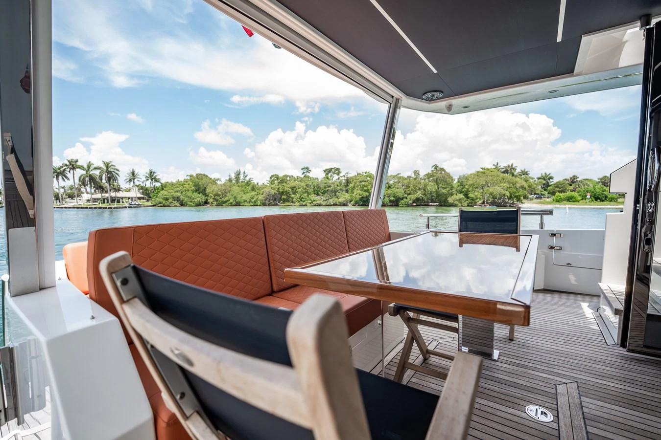 The aft deck features a comfortable seating area with a table, perfect for outdoor dining and relaxation. aboard ELENA Yacht for Sale