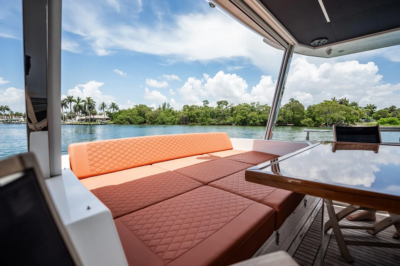 The aft deck features a comfortable lounging area with a stunning view of the water and surrounding greenery. aboard ELENA Yacht for Sale