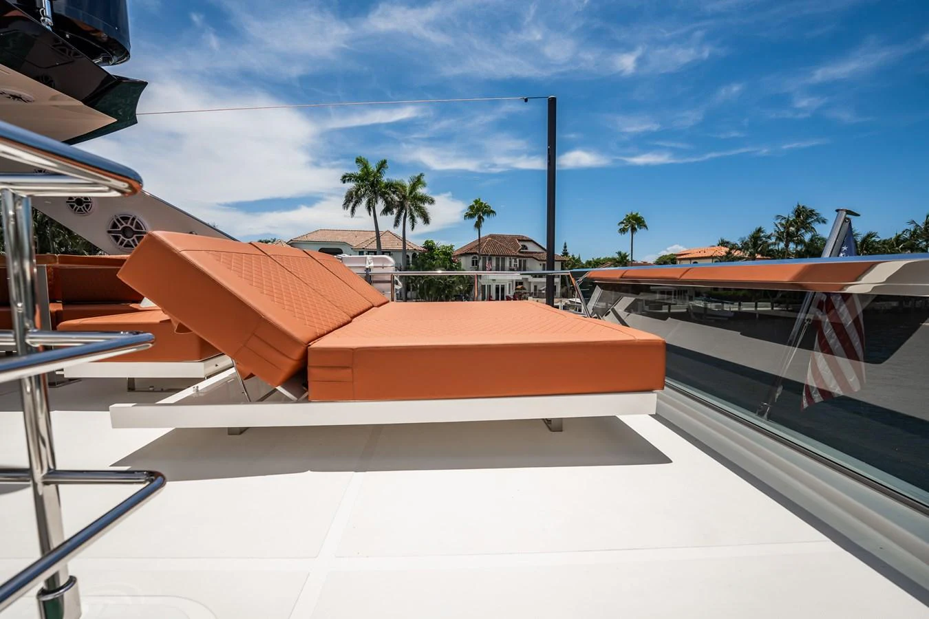The sundeck features luxurious orange loungers under a bright blue sky. aboard ELENA Yacht for Sale