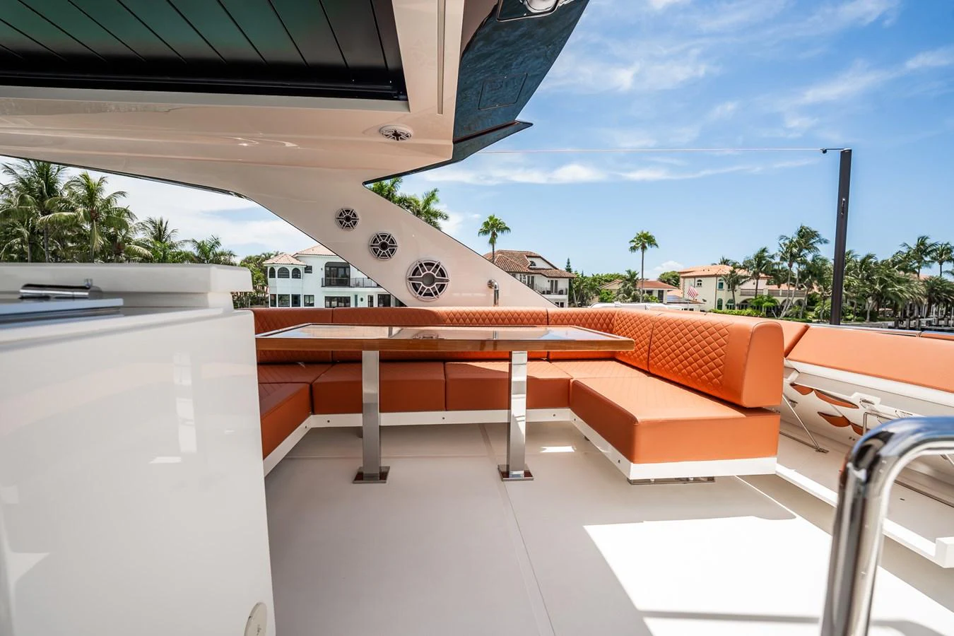 The yacht features a stylish outdoor seating area with orange cushions and a sleek table, perfect for alfresco dining. aboard ELENA Yacht for Sale