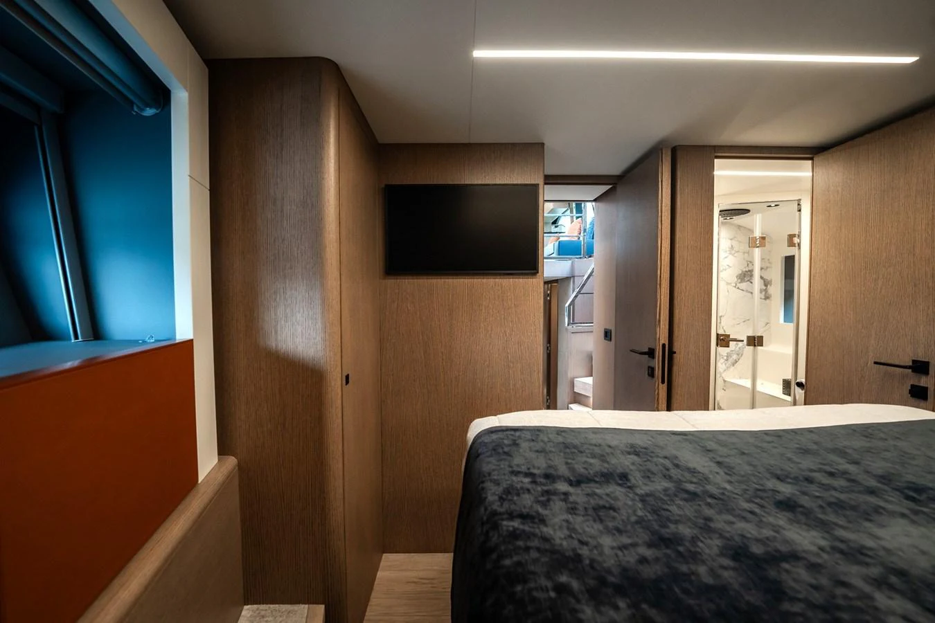 A cozy stateroom with modern furnishings and a view into the ensuite bathroom. aboard ELENA Yacht for Sale