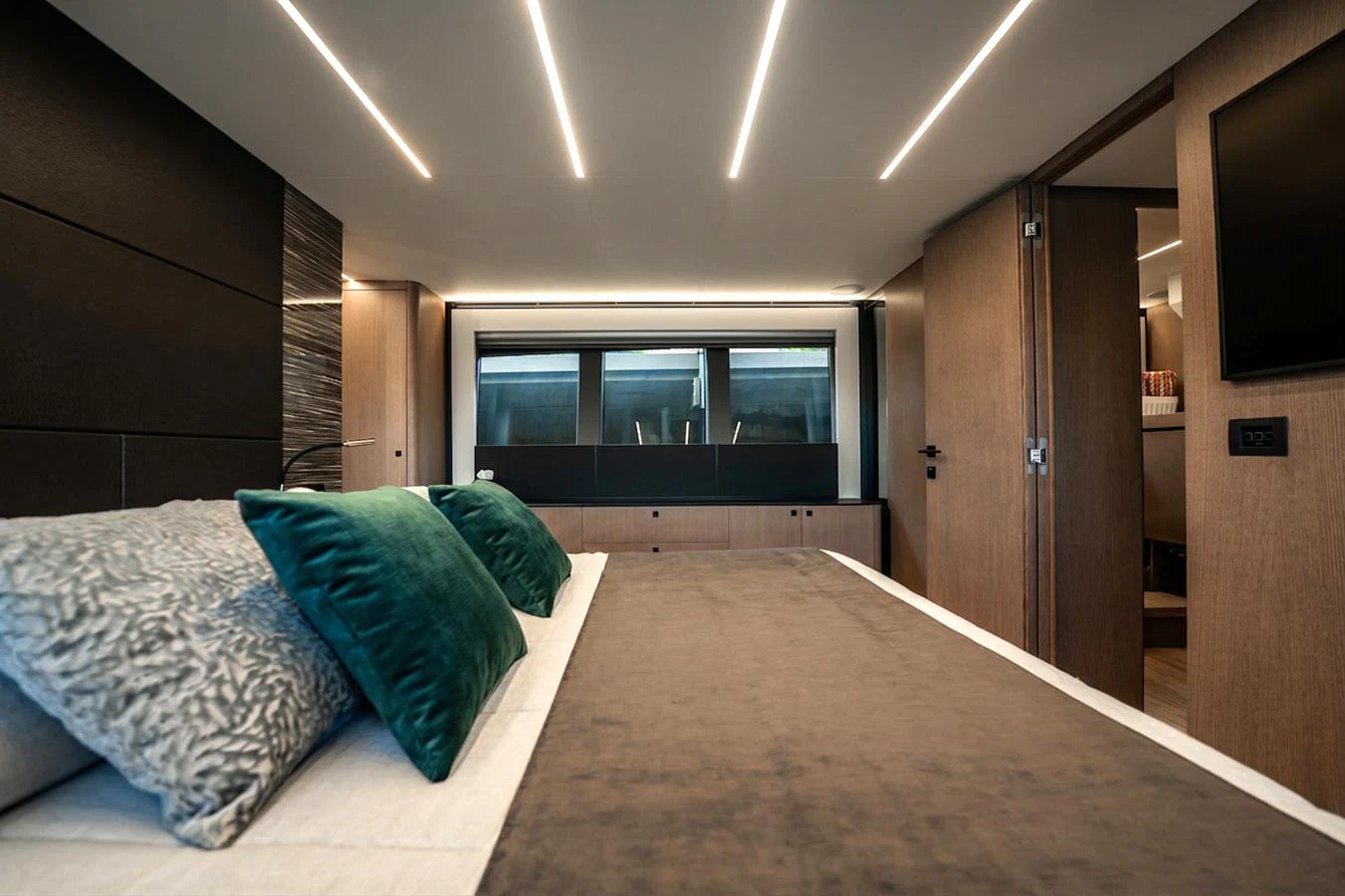 The stateroom features a luxurious bed with plush pillows and modern lighting. aboard ELENA Yacht for Sale