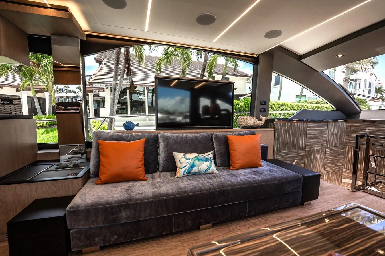 The salon features a plush sofa with vibrant cushions, a large TV, and modern decor. aboard ELENA Yacht for Sale
