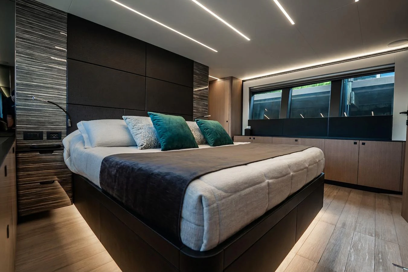 The stateroom features a luxurious bed with modern design elements and ample natural light. aboard ELENA Yacht for Sale