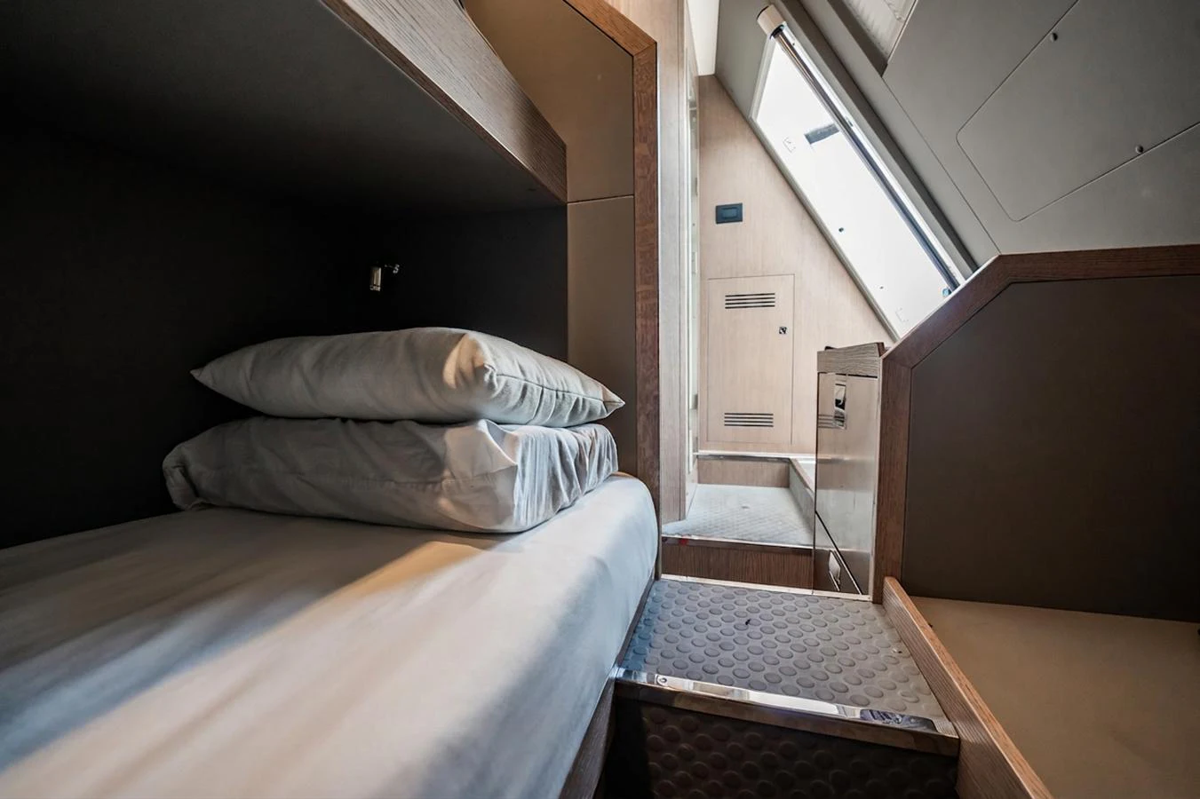 A cozy cabin with a neatly made bed and modern design elements. aboard ELENA Yacht for Sale