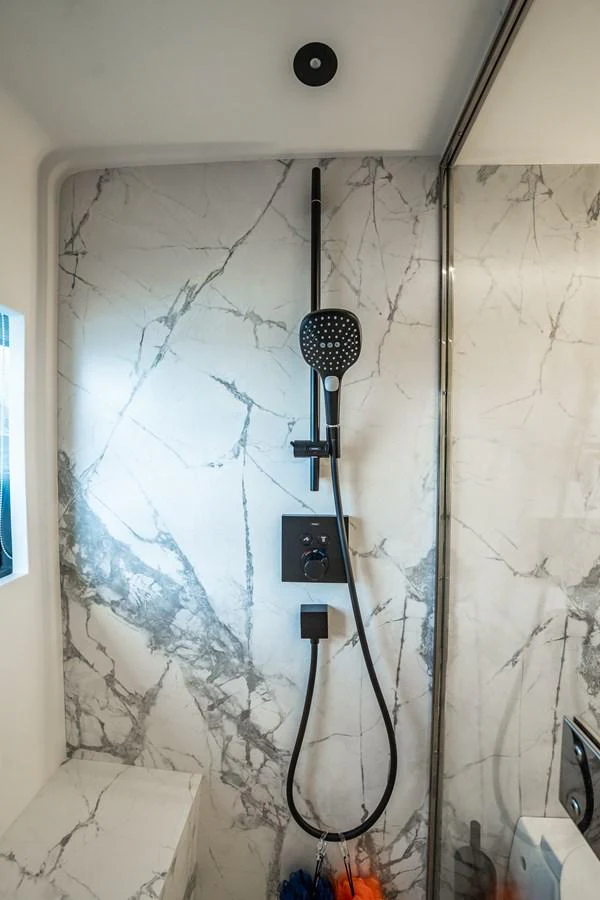 The yacht's shower features elegant marble walls and modern fixtures. aboard ELENA Yacht for Sale
