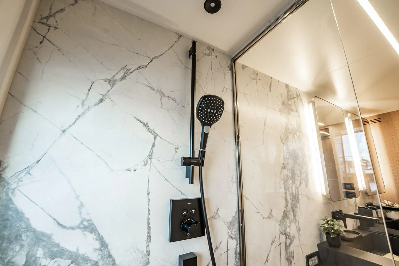 The yacht's bathroom features a luxurious marble shower with modern fixtures. aboard ELENA Yacht for Sale