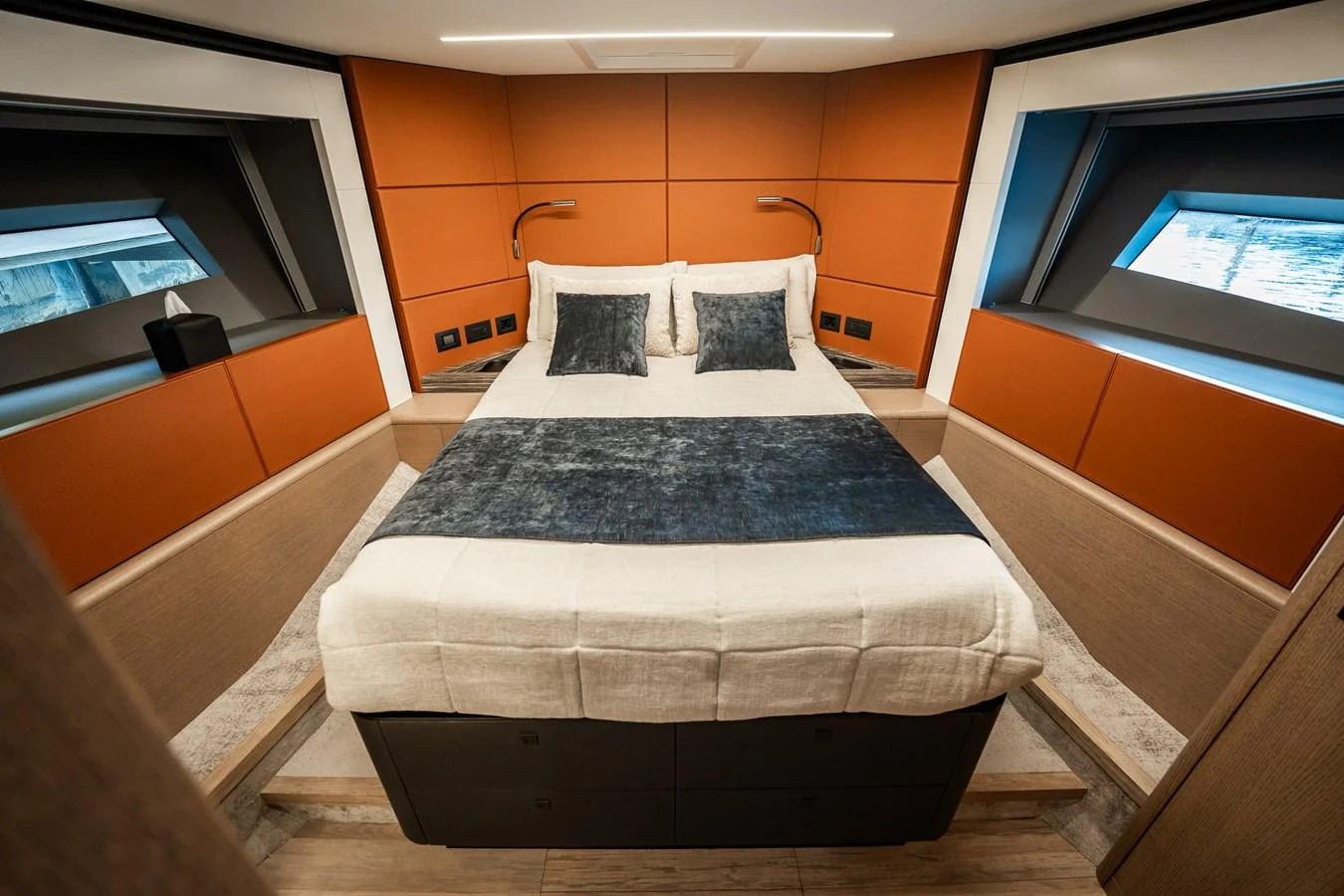 The stateroom features a luxurious bed with modern design elements and ample natural light from large windows. aboard ELENA Yacht for Sale