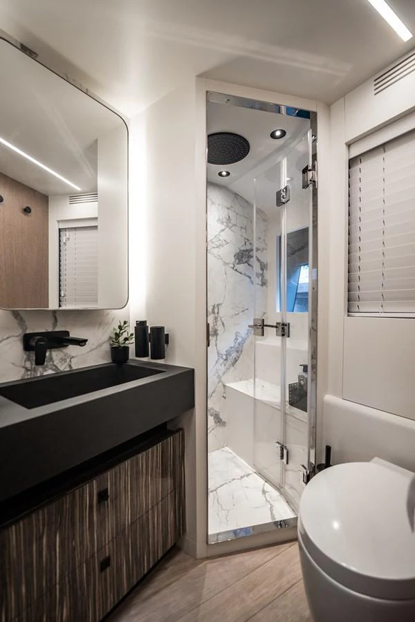 The yacht's bathroom features a sleek design with modern fixtures and a luxurious shower area. aboard ELENA Yacht for Sale