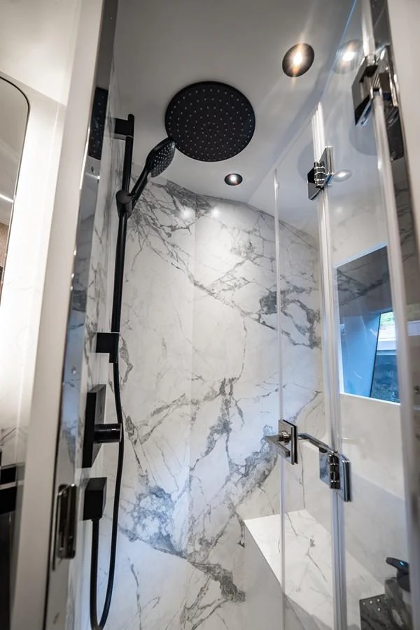 The yacht's bathroom features a luxurious marble shower with modern fixtures. aboard ELENA Yacht for Sale