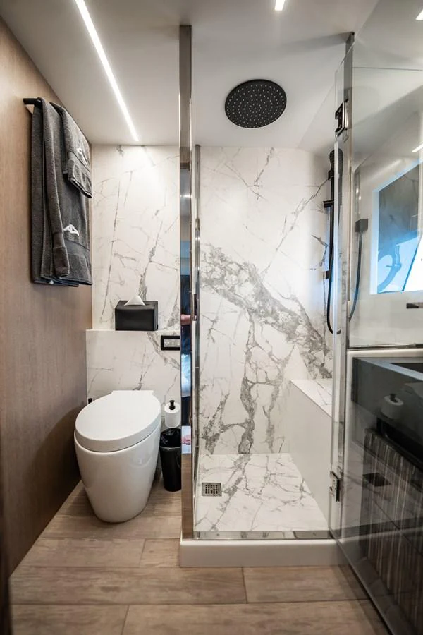 The yacht's bathroom features a sleek, modern design with marble accents and high-end fixtures. aboard ELENA Yacht for Sale