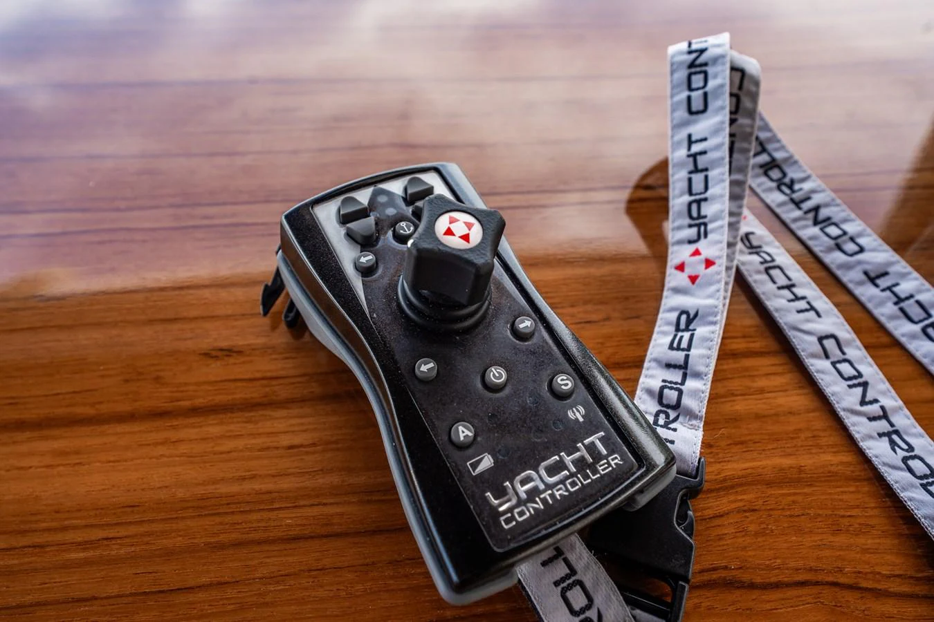 A close-up of a yacht controller placed on a polished wooden surface. aboard ELENA Yacht for Sale