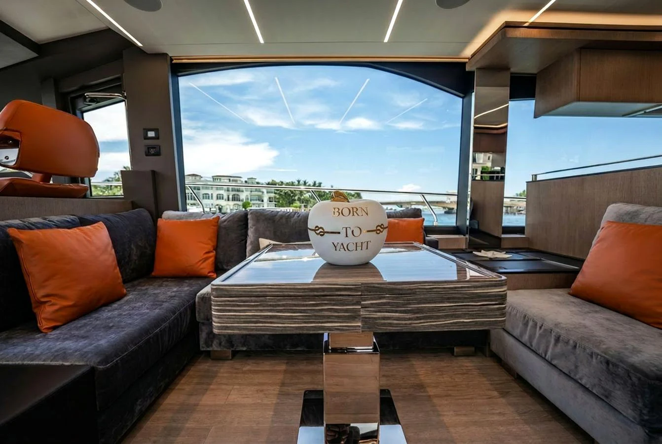 The salon features luxurious seating with vibrant orange cushions and a stylish table centerpiece. aboard ELENA Yacht for Sale