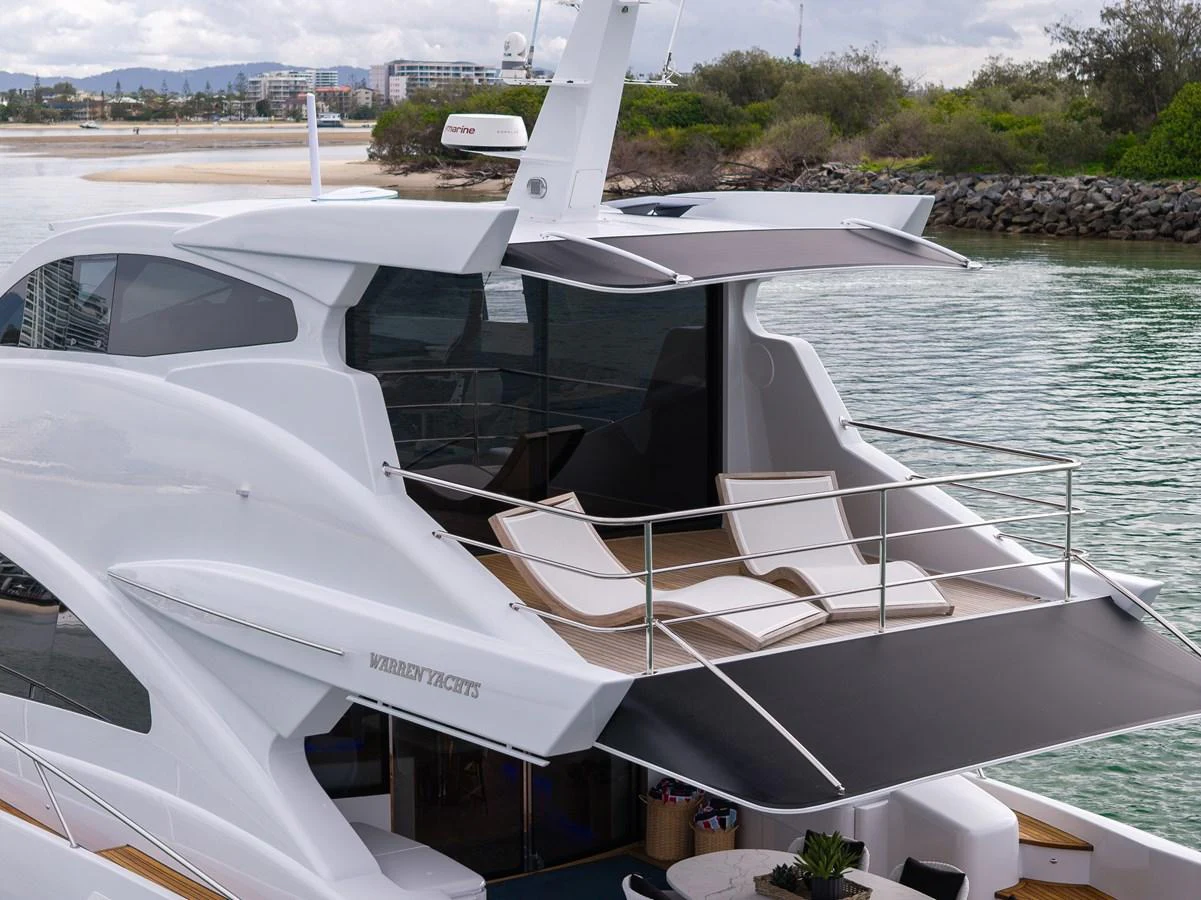 The yacht features a luxurious aft deck with sun loungers and a retractable sunshade, perfect for relaxation. aboard WARREN 87 Yacht for Sale
