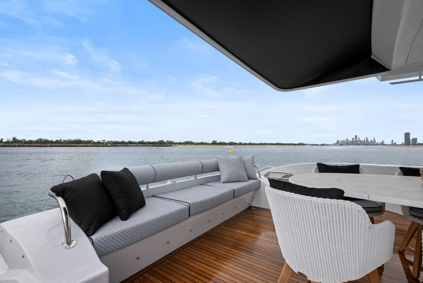 The aft deck offers a luxurious seating area with a stunning view of the water and city skyline. aboard WARREN 87 Yacht for Sale