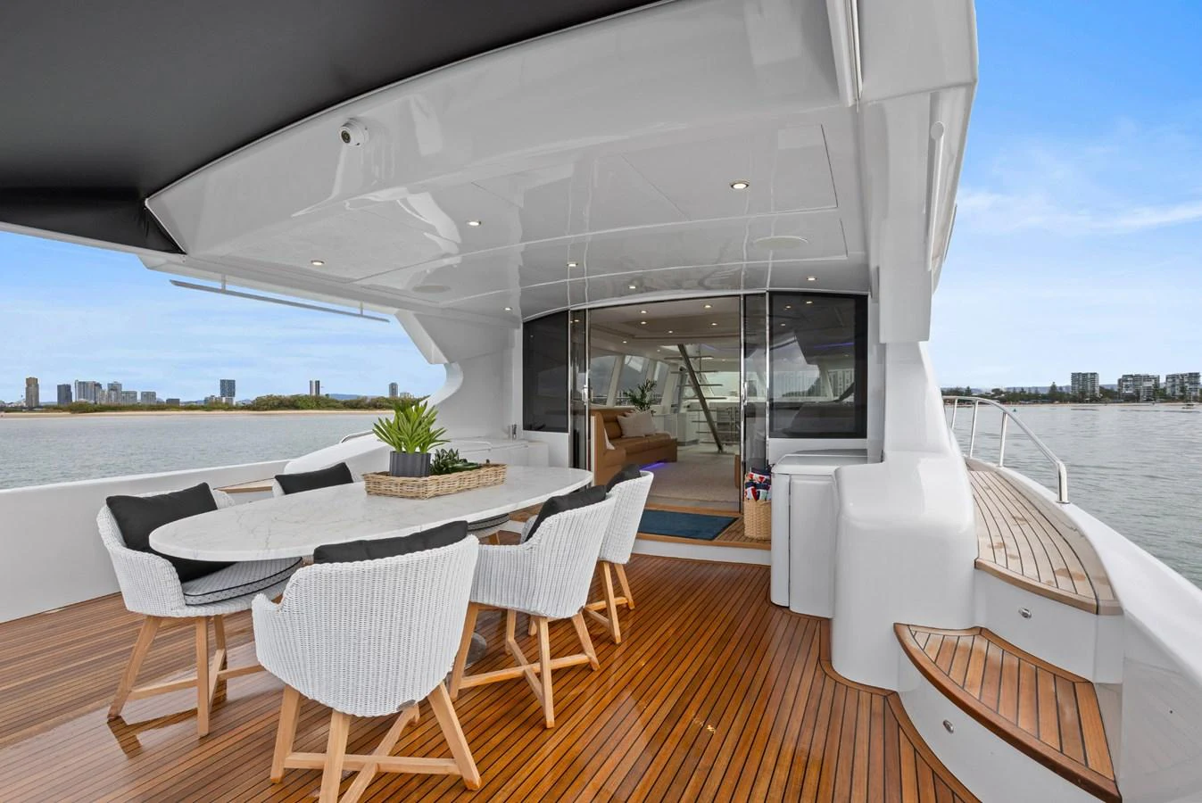 The aft deck features a stylish dining area with a sleek table and comfortable chairs, perfect for alfresco meals with a view. aboard WARREN 87 Yacht for Sale