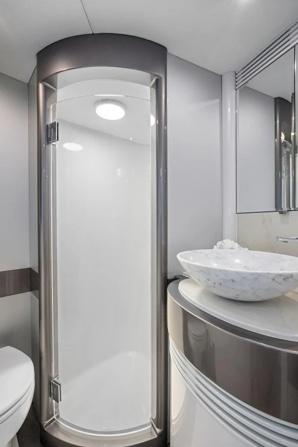 A sleek and modern yacht bathroom featuring a glass-enclosed shower and a stylish sink. aboard WARREN 87 Yacht for Sale