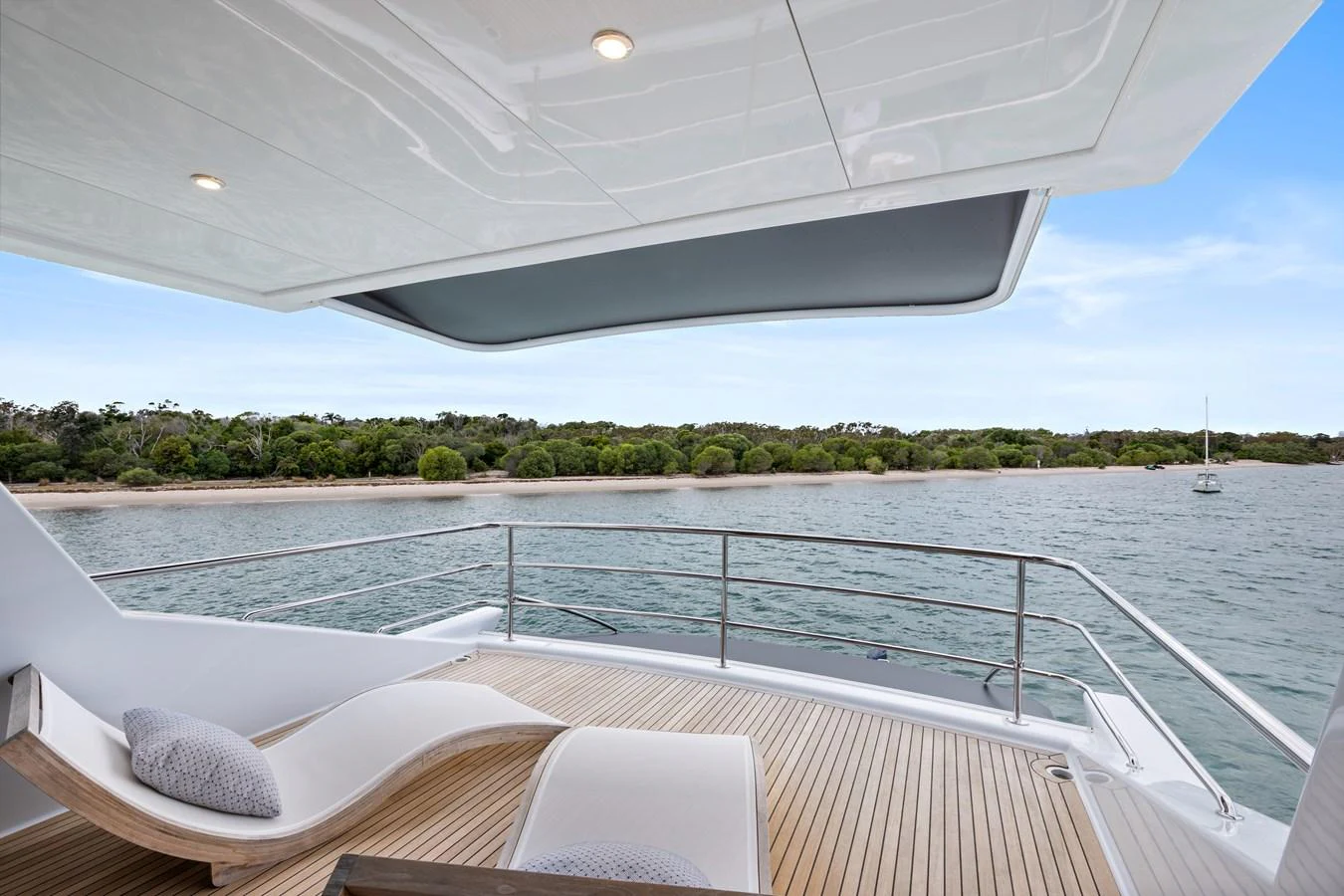 The aft deck offers a serene view of the water and surrounding landscape, complemented by comfortable lounge chairs. aboard WARREN 87 Yacht for Sale