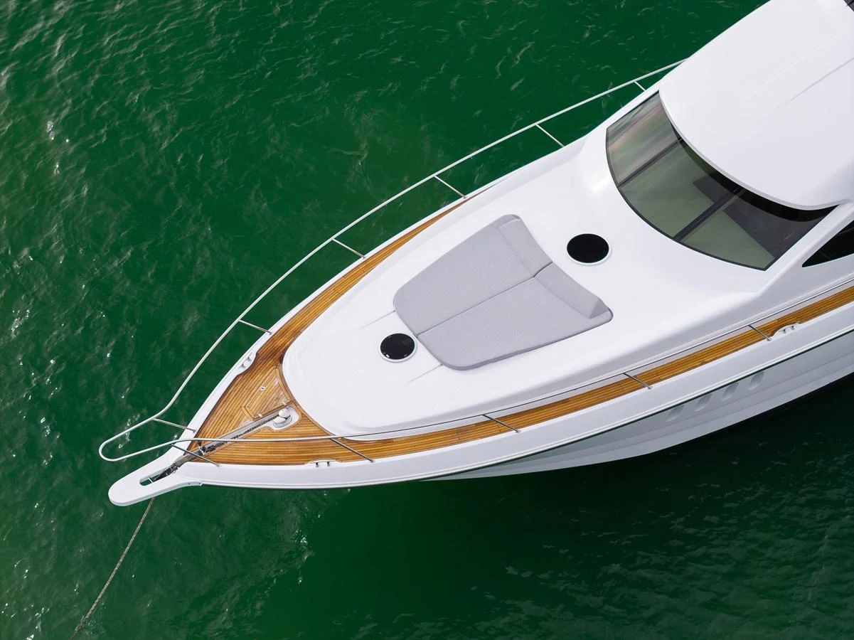 The sleek bow of the yacht cuts through the emerald waters with elegance. aboard WARREN 87 Yacht for Sale