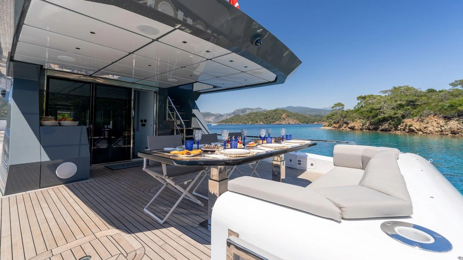 The aft deck offers a spacious dining area with stunning views of the surrounding waters. aboard FERRO 77 Yacht for Sale