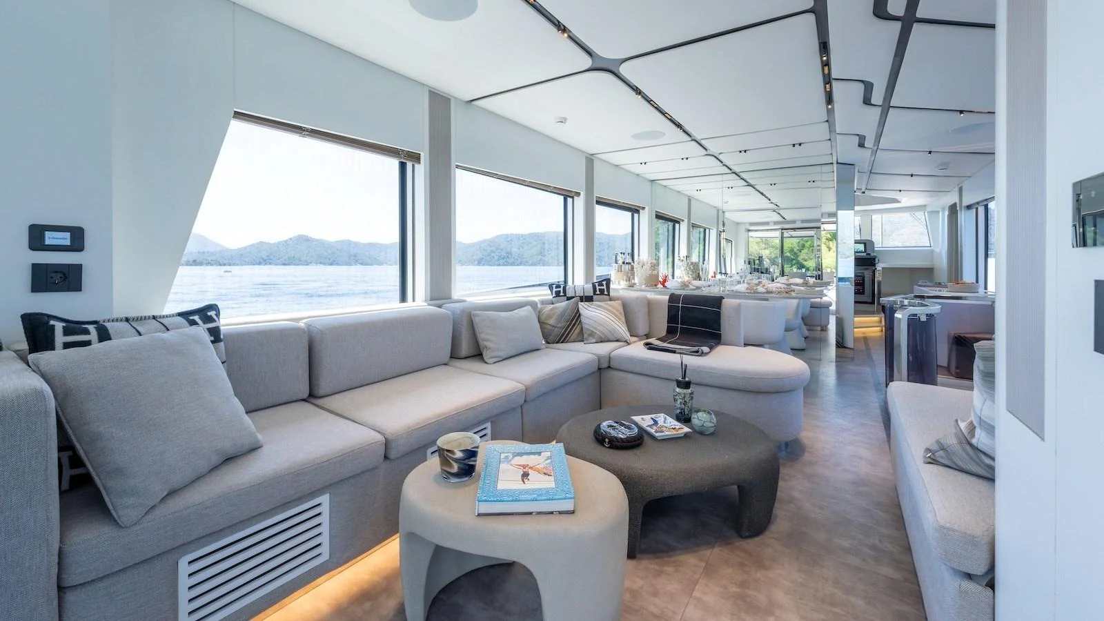 The salon features expansive windows and modern furnishings, offering a luxurious and comfortable space with stunning views. aboard FERRO 77 Yacht for Sale