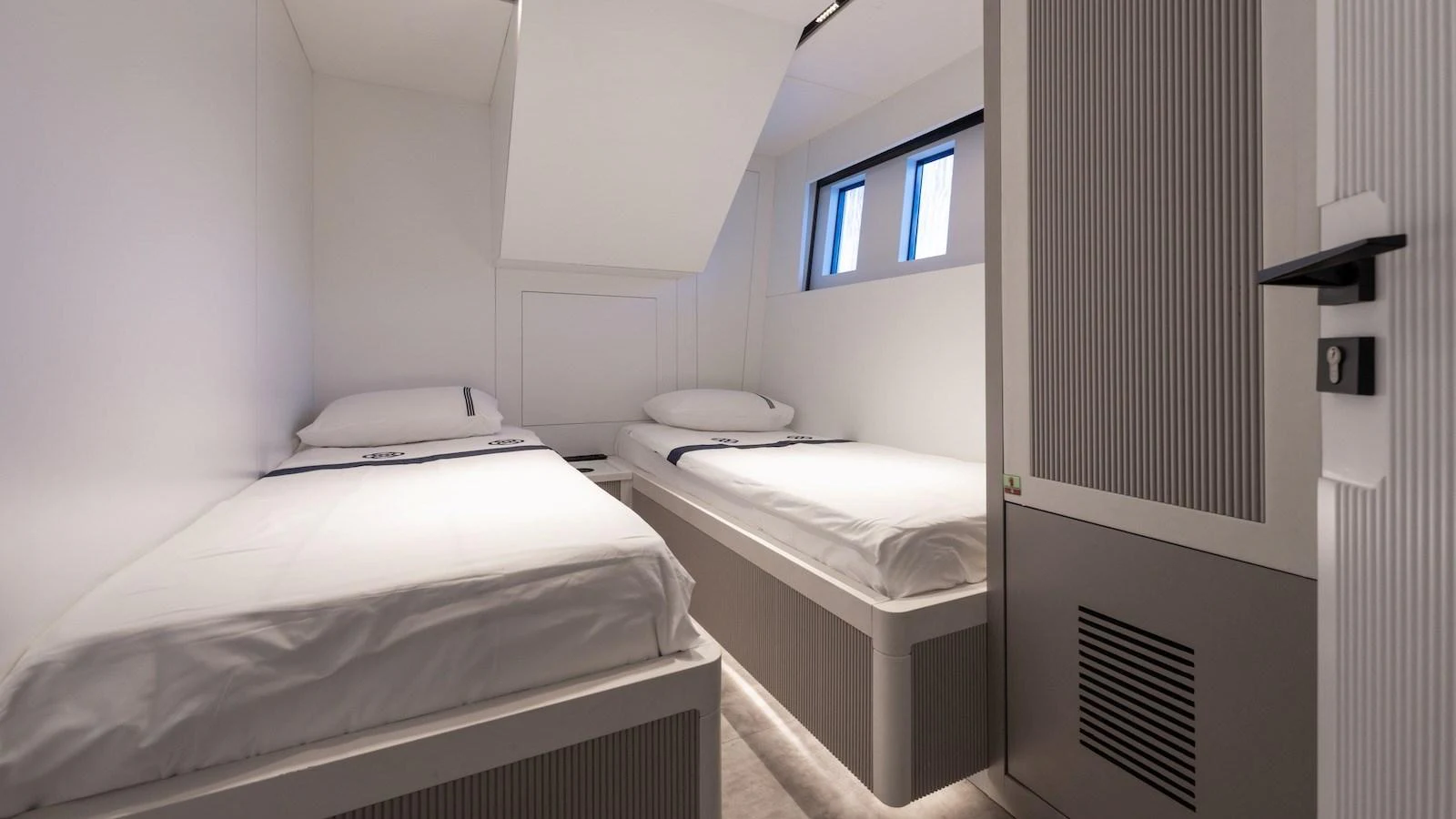 The twin cabin offers a minimalist and cozy sleeping area with two single beds and modern decor. aboard FERRO 77 Yacht for Sale