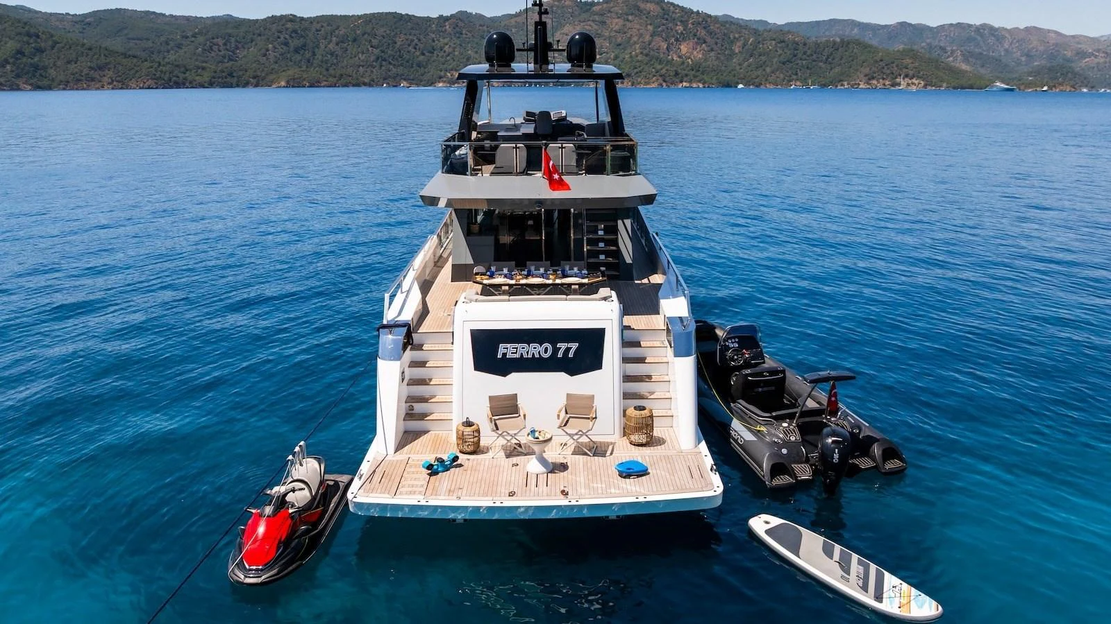 The yacht's aft deck is equipped with lounging chairs and water toys, perfect for a day of relaxation and fun on the water. aboard FERRO 77 Yacht for Sale