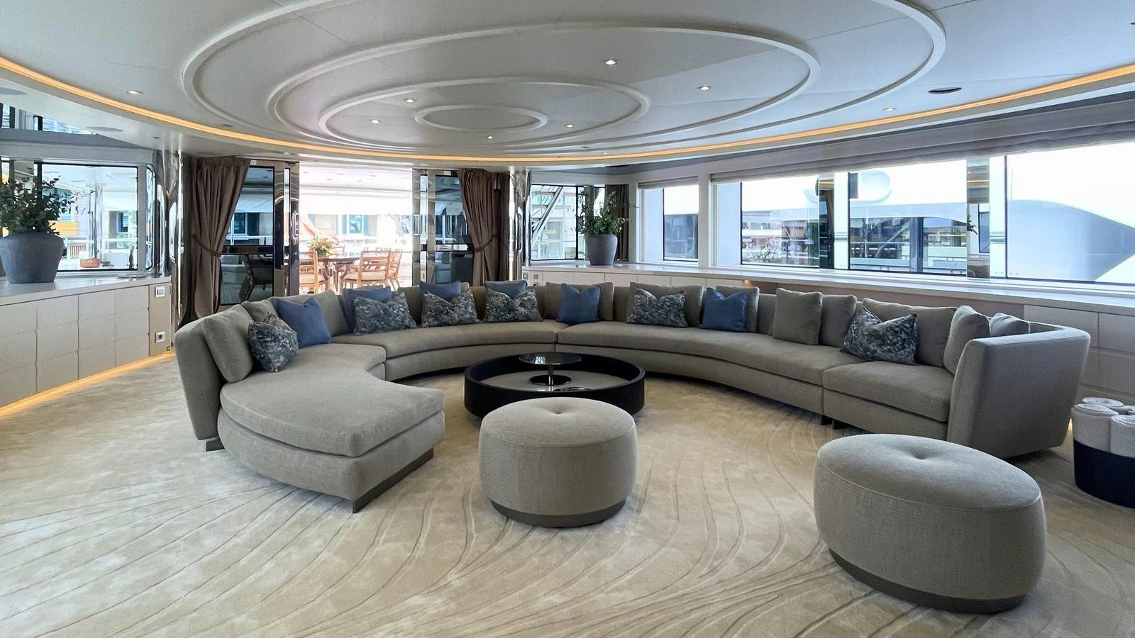 The salon features a spacious and elegantly curved seating arrangement with modern decor. aboard ELENI 60M Yacht for Sale