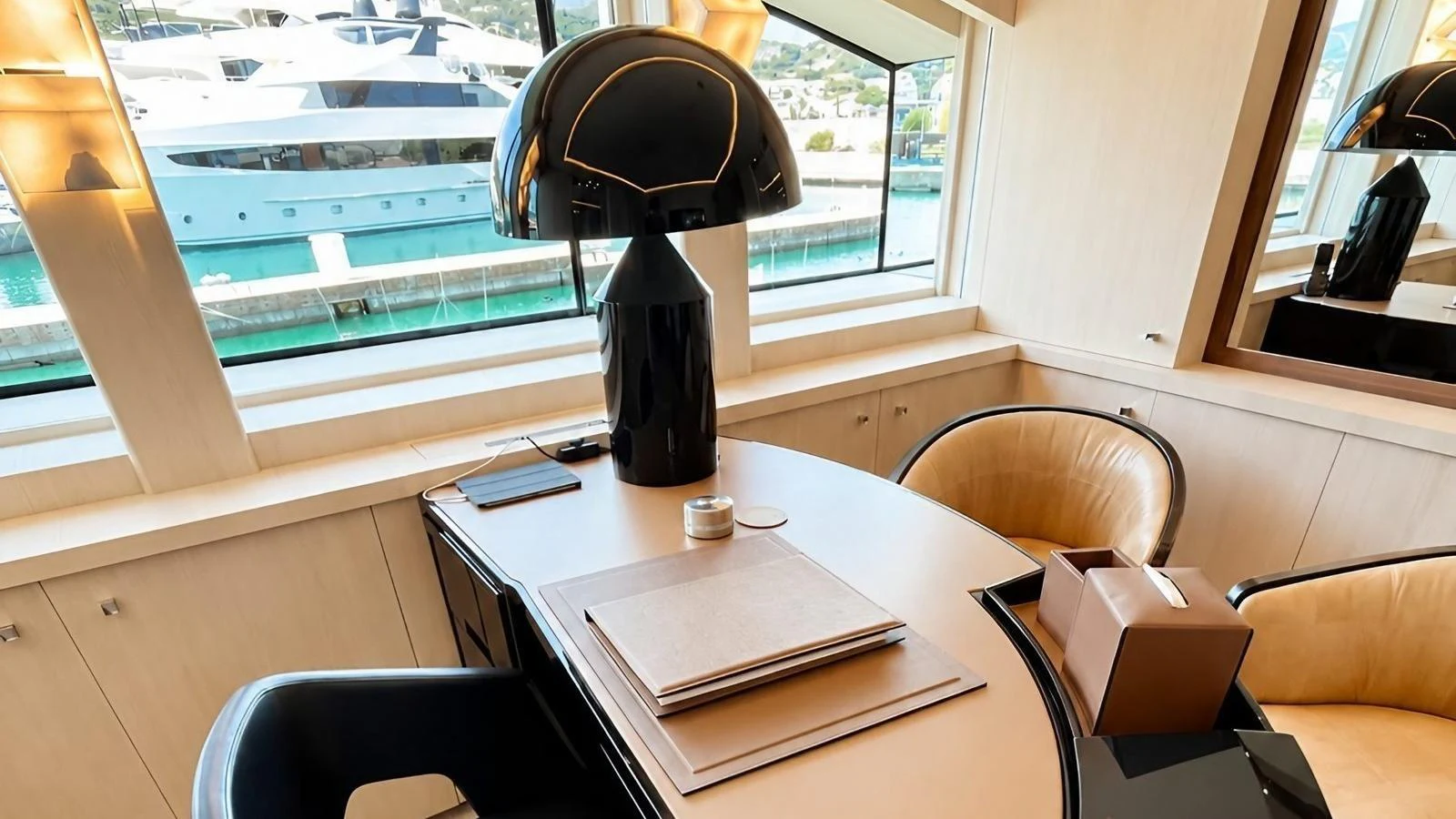 A sophisticated office space with a view of the marina, featuring a sleek desk and modern lamp. aboard ELENI 60M Yacht for Sale