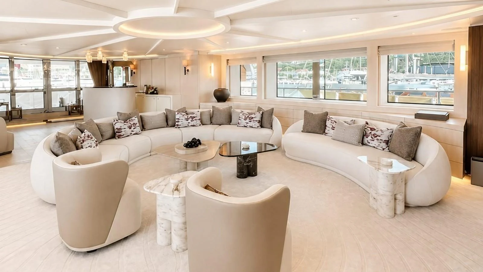 The salon features a spacious and elegant seating area with large windows offering a view of the marina. aboard ELENI 60M Yacht for Sale