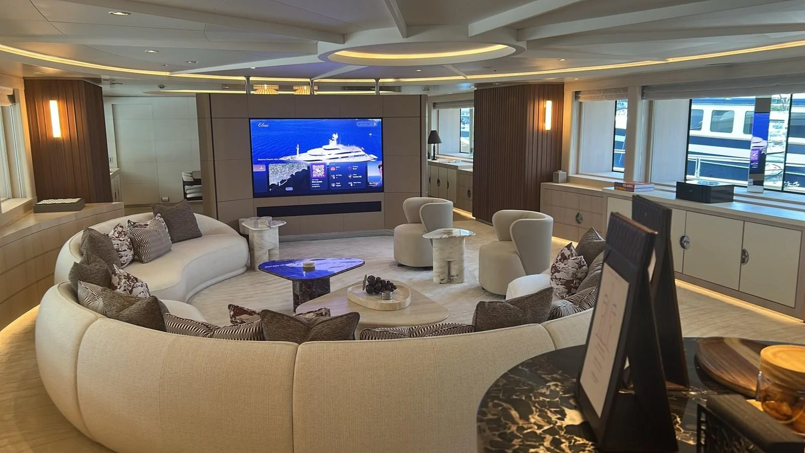 The salon features a spacious and elegantly designed seating area with a large TV and ample natural light. aboard ELENI 60M Yacht for Sale
