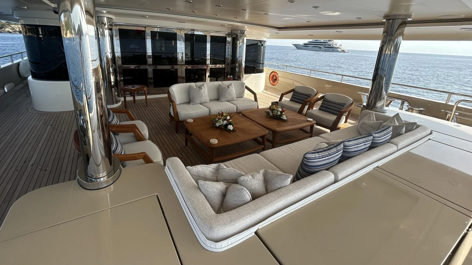 The aft deck features a spacious seating area with plush sofas and a large wooden table, perfect for relaxation and socializing. aboard ELENI 60M Yacht for Sale