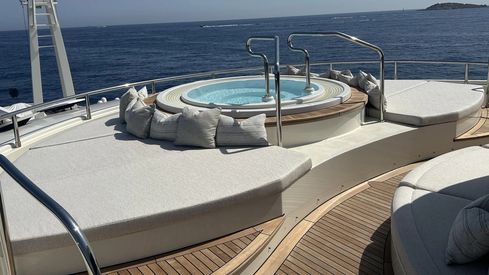 The sundeck features a luxurious jacuzzi surrounded by comfortable sun loungers and plush cushions, offering a perfect relaxation spot with a stunning ocean view. aboard ELENI 60M Yacht for Sale