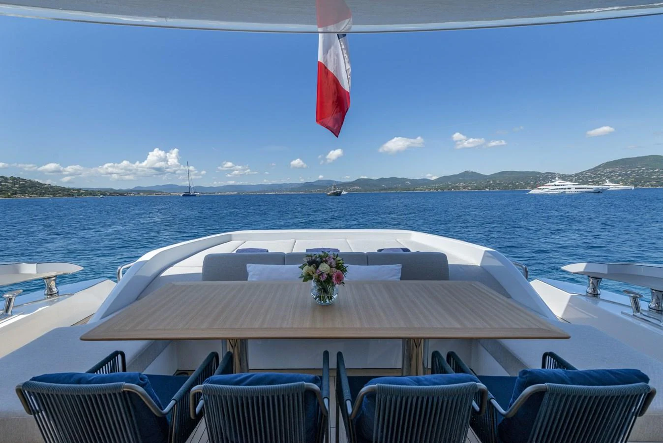 The aft deck features a spacious dining area with a stunning view of the open sea. aboard AMER 120/11 Yacht for Sale