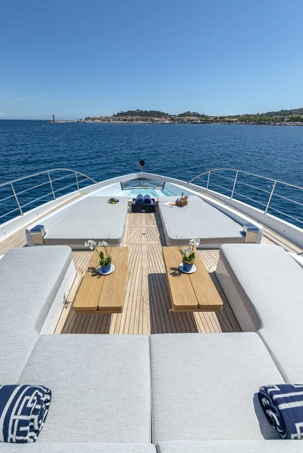 The foredeck features spacious sun pads and elegant wooden tables, perfect for relaxation and enjoying the view. aboard AMER 120/11 Yacht for Sale