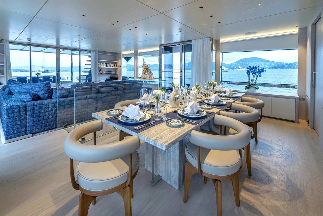 The yacht's dining area features elegant table settings and a panoramic view of the sea. aboard AMER 120/11 Yacht for Sale