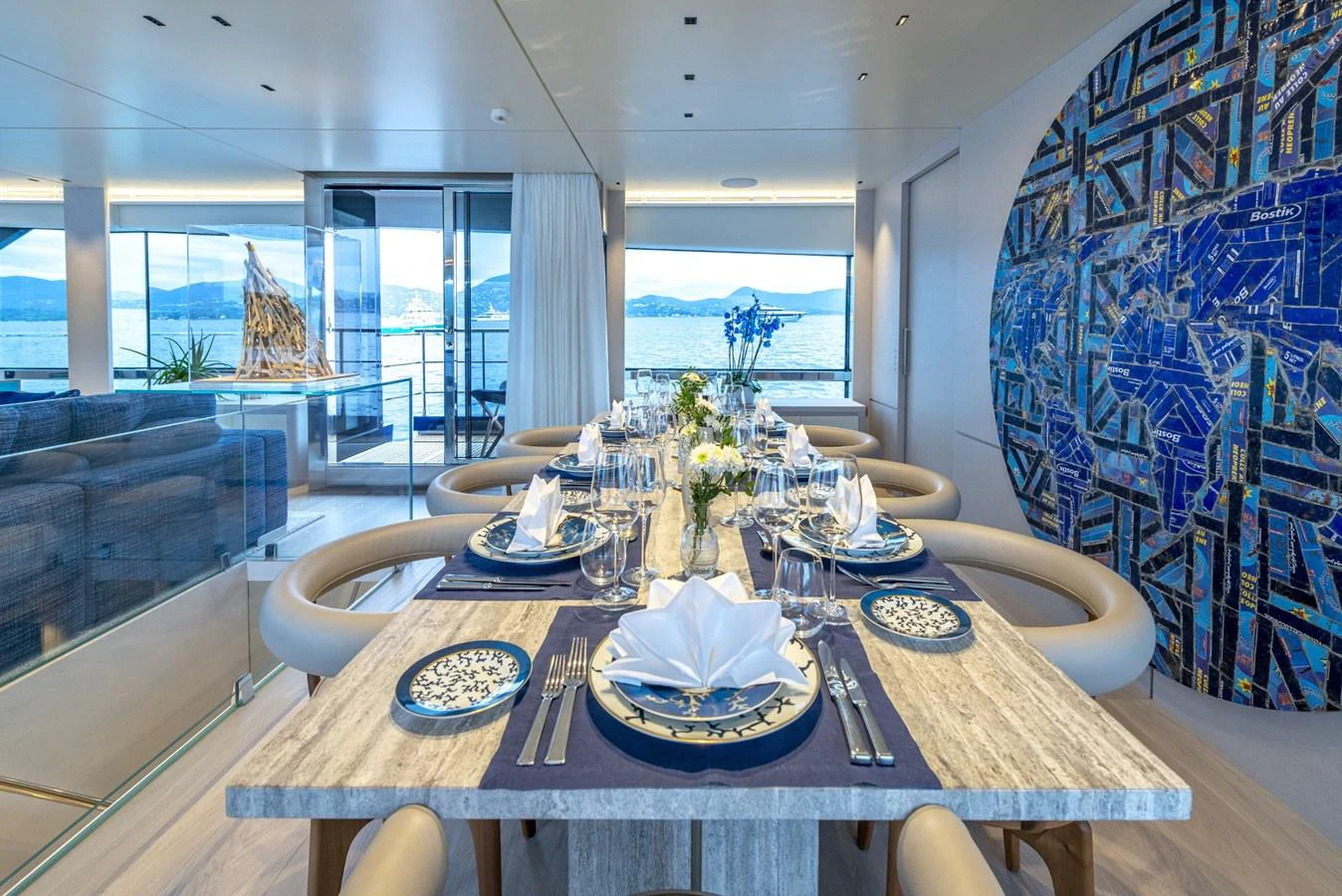 The yacht's dining area features a beautifully set table with a stunning ocean view. aboard AMER 120/11 Yacht for Sale