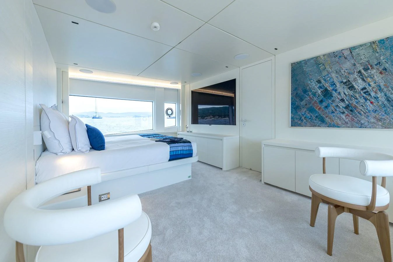 The stateroom features a spacious bed, modern furnishings, and a large window with a serene view. aboard AMER 120/11 Yacht for Sale