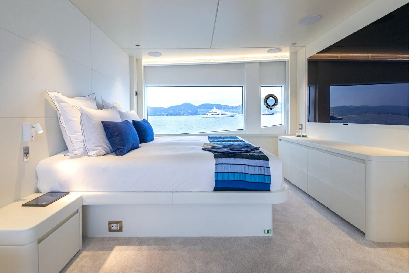 A luxurious stateroom with a large bed, modern decor, and a scenic view through the window. aboard AMER 120/11 Yacht for Sale