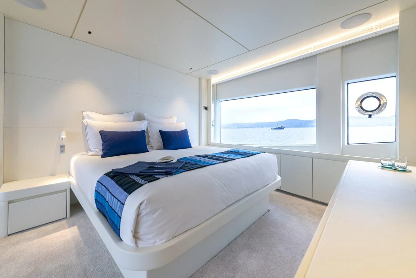 A luxurious stateroom with a large bed and scenic ocean views through the window. aboard AMER 120/11 Yacht for Sale