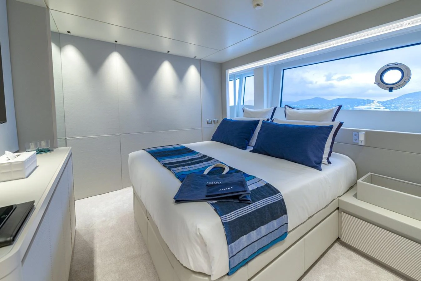 The stateroom features a luxurious bed with a view of the sea through a large window. aboard AMER 120/11 Yacht for Sale