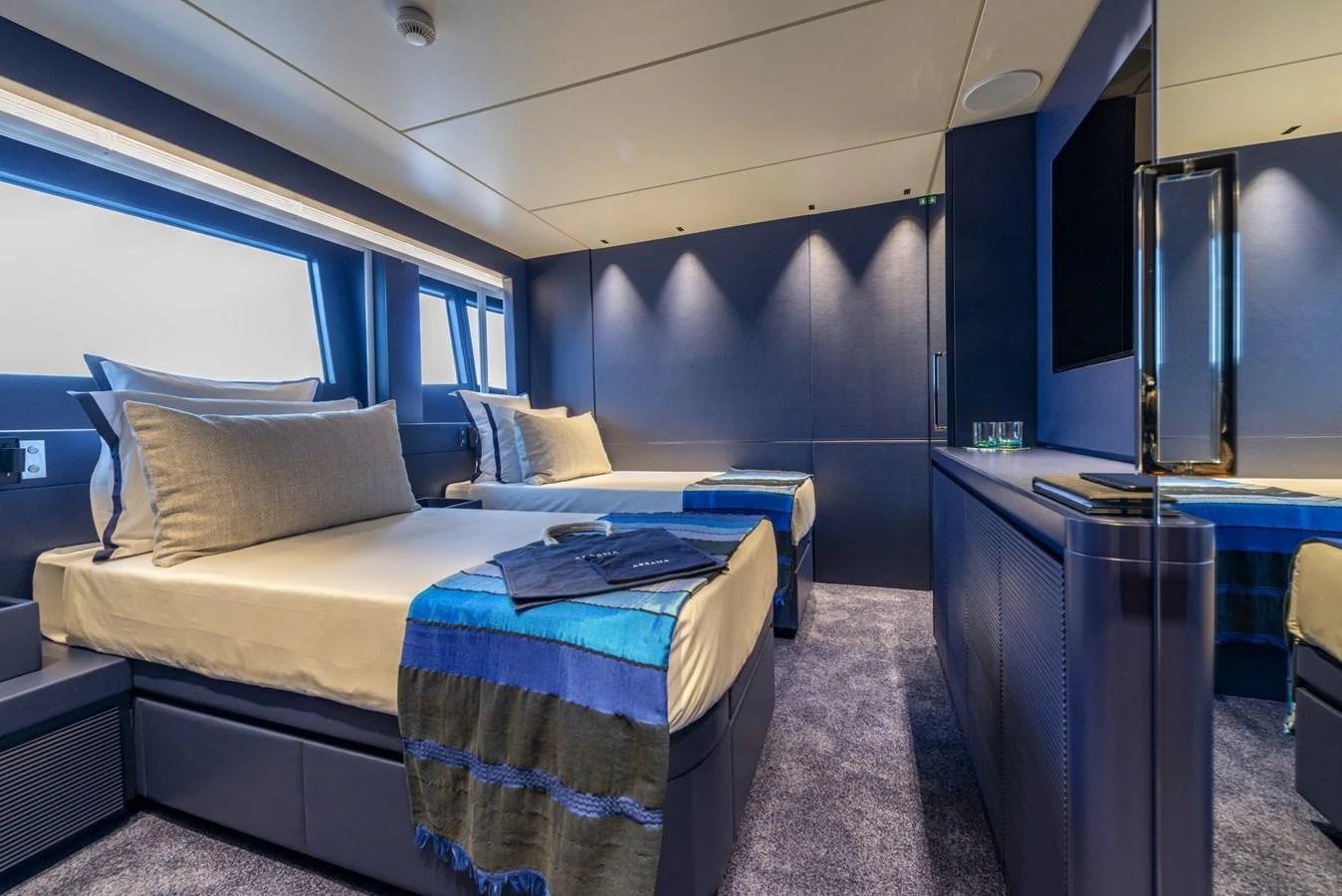 The guest stateroom features twin beds with luxurious bedding and modern decor. aboard AMER 120/11 Yacht for Sale